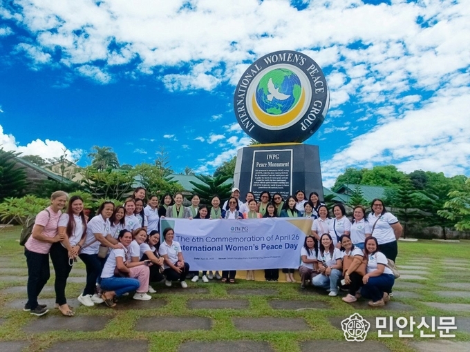 제6회 '세계여성평화의 날' 기념식에 참석한 IWPG 회원들이 평화기념비 앞에서 기념 촬영을 하고 있다
