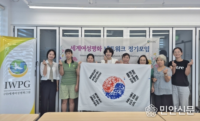 완성된 태극기와 함께 광복 80주년을 기념하는 IWPG 회원들의 모습
